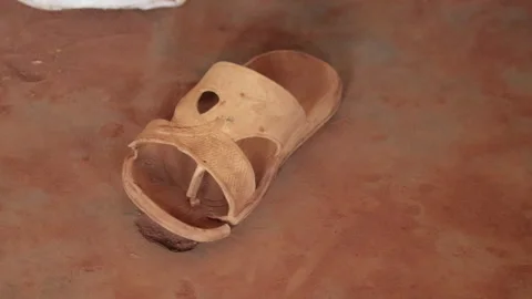 Old rubber slipper on muddy surface in Uganda Stock Footage 278512106