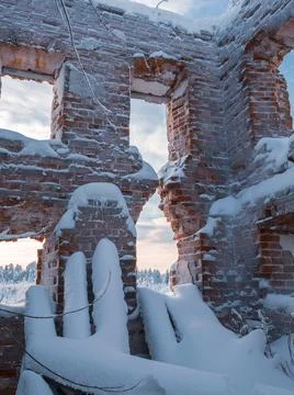 An old ruined brick building with empty windows. Instead of a roof there is a Stock Photos