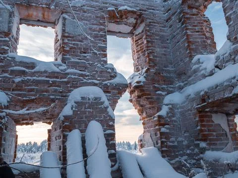 An old ruined brick building with empty windows. Instead of a roof there is a Stock Photos
