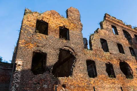 An old ruined building, without windows or doors, made of red bricks. The Stock Photos