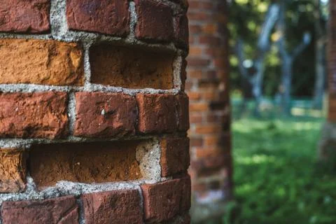 Old, ruined red brick columns. The entrance to the old, ruined stable Stock Photos