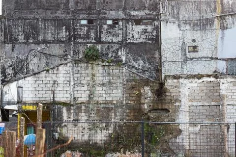 Old run down brick wall with broken windows crumbling facade Fotos de archivo