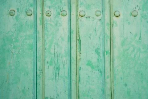 Old run-down green painted wooden door and iron nails Foto stock