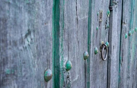 Old run-down green painted wooden door and iron nails Stock Photos