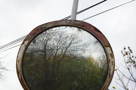 Old rust traffic mirror. Forest in the reflection Stock Photos