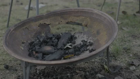 Old rusted fire pit with coal pile in backyard Stock Footage 226450458
