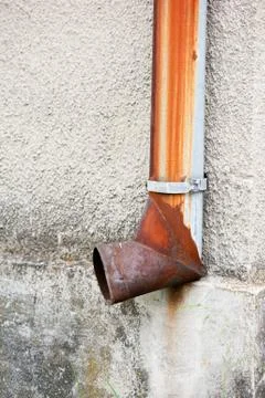 Old rusted gutter downspout pipe on wall Stock Photos