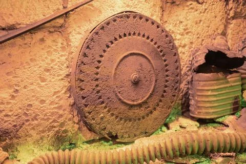 Old, rusted metal object with three wheels central and two smaller, adorned w Stockfoto's