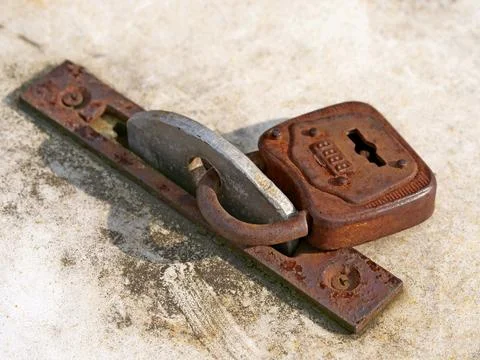 Old rusted padlock secures a floor panel Stock Photos