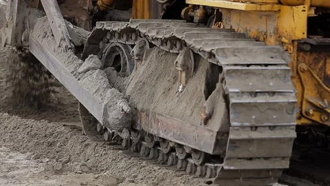 An old rusted tractor is reversing, covered in dirt and earth, dirt on tracks Stock Footage 115925080