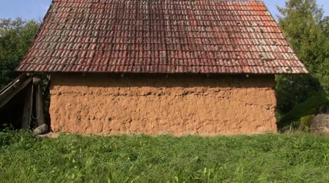 Old rustic barn with clay wall in meadow in village Stock Footage 57773239