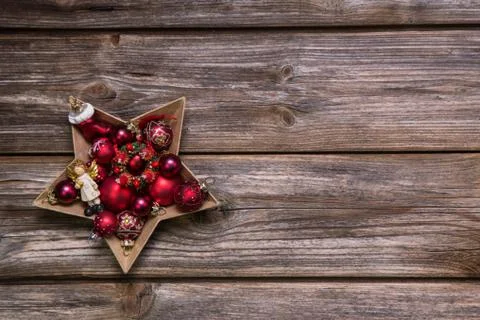 Old rustic christmas background with red advent balls like a star. Stock Photos