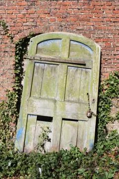 Old rustic door with padlock and broken hinges Stock Photos