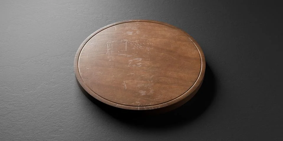 Old rustic empty round wooden cutting or chopping board on black stone back.. Illustrazione stock
