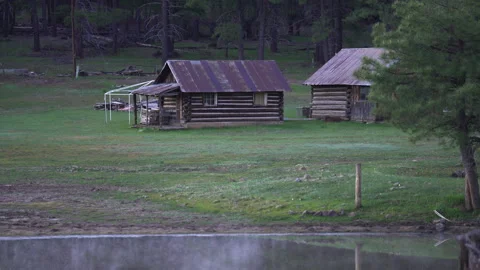 An old rustic log cabin on a forest meadow Stock Footage 243322891