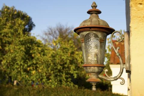 Old Rustic Outside Street Lantern on a Brick Wall with Trees in the Background Stock Photos