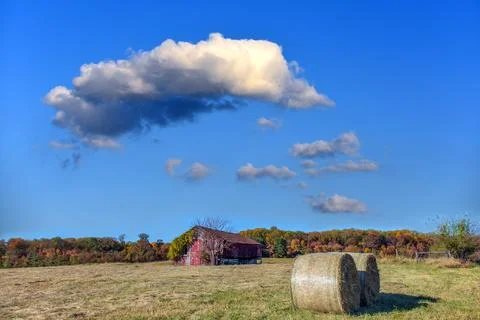 Old rustic Red Barn on a farm during Autumn with fall colors and hay bales Stock Photos