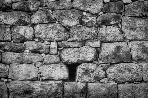 Old rustic stone wall in black and white with varied and sizes and textures Fotos de archivo
