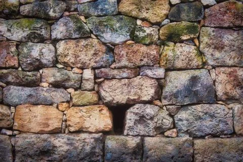 Old rustic stone wall with varied colors and sizes and textures Stock Photos