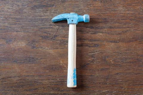 Old rustic toy carpenter hammer on wooden table. Stock Photos