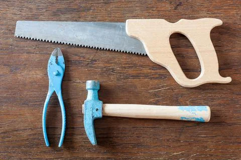Old rustic toy carpenter tools on wooden table. Foto stock
