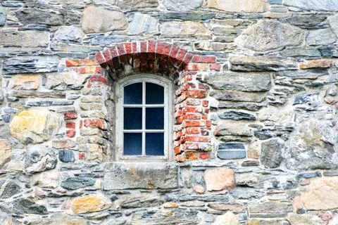 Old rustic window on a stone wall. Stock Photos