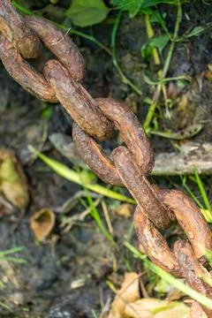An old rusty anchor chain. Fixing the boat on the pier. Rusty iron constructi Stock Photos