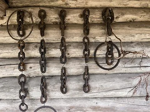 Old rusty anchor chains hanging on a barn wall Stock Photos