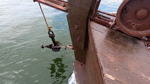 Old rusty anchor hanging rope, staggering near bow of stern floating wooden ship Stock Footage 242900342