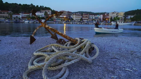 Old rusty anchor with a rope at sunset Stock Footage 261313552