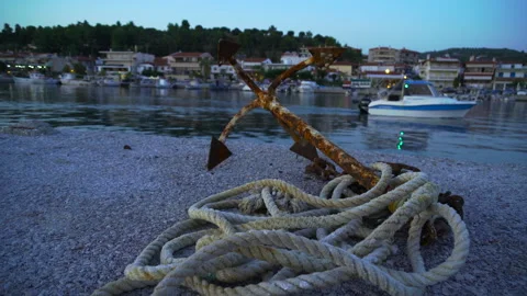 Old rusty anchor with a rope at sunset Stock Footage 261323471