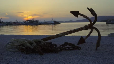 Old rusty anchor with a rope at sunset Stock Footage 261324672