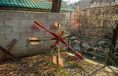 Old rusty and abandoned carousel in front of old house Stockfoto's