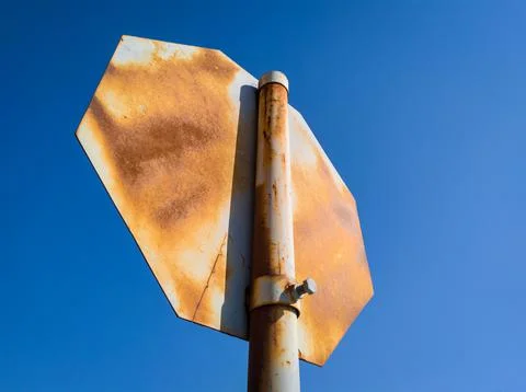 Old rusty and battered Stop traffic sign, that should be replaced. The back Stock Photos