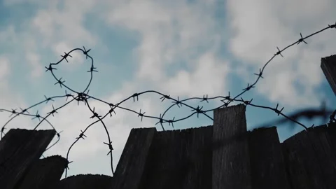 Old rusty barbed wire on a wooden fence. Shooting a fence against the sky Stock Footage 162828813