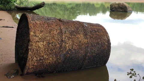 Old rusty barrel washed ashore by the sea Stock Footage 283583973