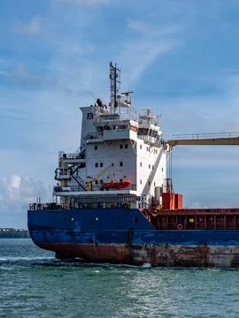 An old rusty big ship is sailing on the sea under a blue sky. cargo ship on sea. Stock Photos
