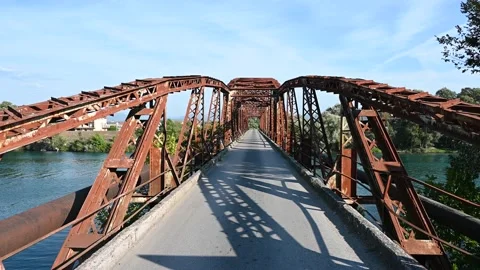 Old rusty bridge over the river. Transportation. Old metal railway bridge Stock Footage 160857983