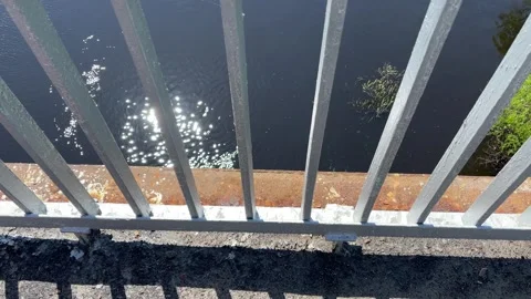 Old rusty bridge railings overlooking the river water 库存影片 306172654