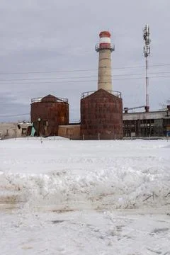 Old, rusty, broken cisterns. Smoke stack. A tower. Ruined buildings. Drifts Stock Photos