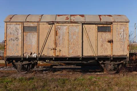 Old rusty brown train wagon on abandoned tracks in the field Stock Photos