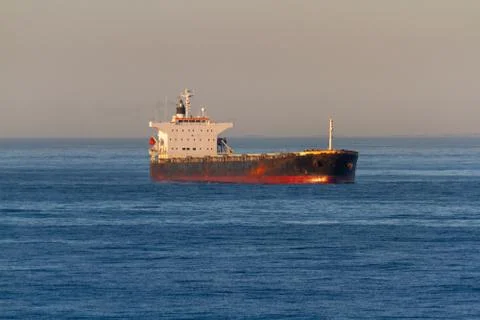 Old rusty bulk cargo ship at anchorage Stock Photos
