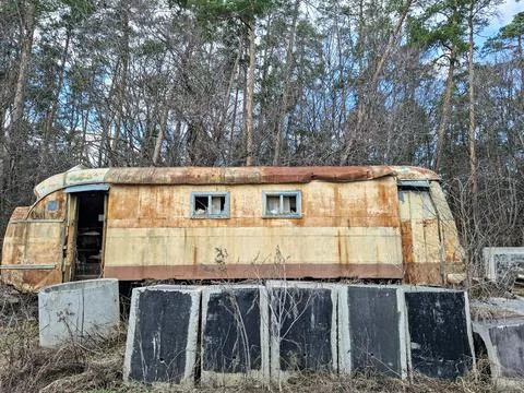 Old rusty bus turned into a home for homeless people in a forest area durin.. Stock-Fotos