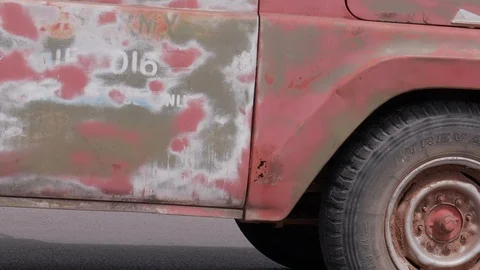 Old Rusty Car Driving Downt the Road Stock Footage 98544591