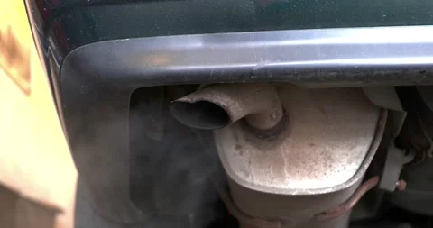 Old rusty car exhaust pipe or muffler emitting polluting smoke Stock Footage 237227905