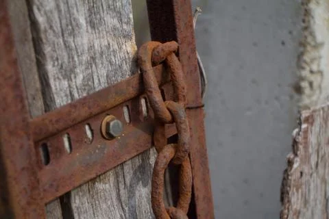 Old rusty chain on a rusty basis on a wall, background or concept, selective  Stock Photos