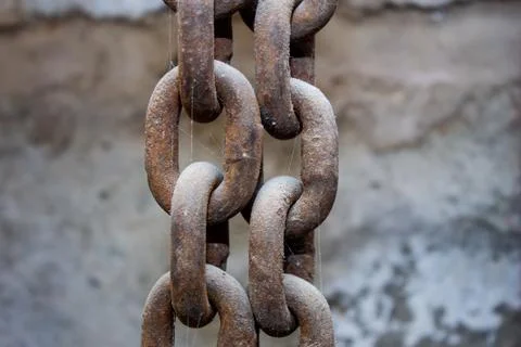 Old rusty chains hang on the background of a shabby wall Stock-Fotos