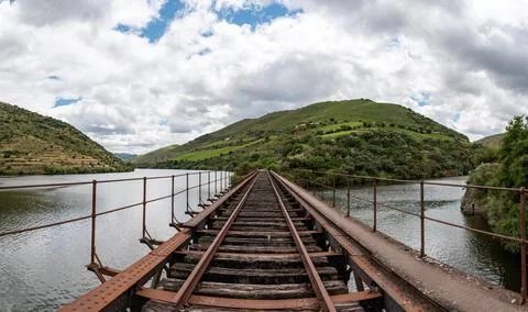 Old rusty closed train tracks leading through the Douro valley towards Porto Stock Photos