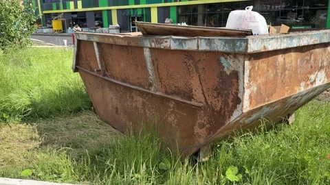 An old rusty container stands motionless in a field overgrown with tall grass Stock Footage 316387141