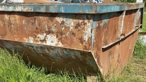 An old rusty container stands motionless in a field overgrown with tall grass Vidéo 316387288